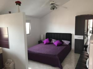 ein Schlafzimmer mit einem lila Bett und lila Kissen in der Unterkunft Vila Nera in Zaboric