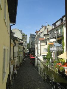 une rue de la ville avec des bâtiments à côté d'un canal dans l'établissement Altstadtwohnung "Klein Venedig", à Fribourg-en-Brisgau