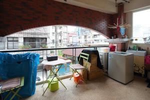 a room with a brick wall and a kitchen with a window at Happiness Yes Hostel 2 in Luodong