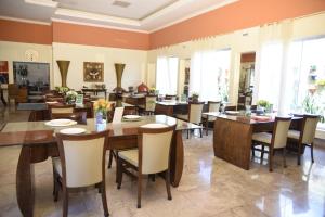a dining room with wooden tables and chairs at Rosa Spa e Pousada in Aparecida de Goiânia