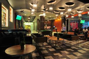 un restaurant avec des tables et des chaises ainsi qu'un bar dans l'établissement Platinum Hotel and Apartments, à Patong Beach