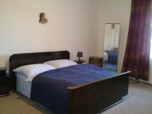 a bedroom with a large bed with a blue blanket at Statek Kloubek in Chabičovice