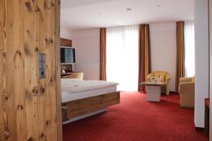 a hotel room with a bed with a wooden wall at Hotel Salinensee in Bad Dürrheim