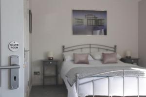 a bedroom with a bed with pink pillows at Firbank Lodge in Glenrothes