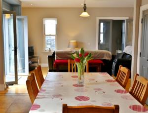 a dining room table with a vase of flowers on it at 11 Doolin Court in Doolin