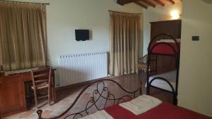 1 dormitorio con 1 cama y TV en la pared en L'Antico Casale, en Perugia