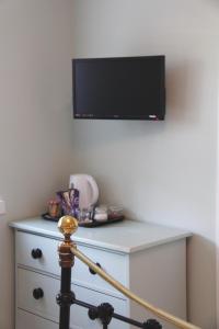 a tv on a wall above a dresser at Firbank Lodge in Glenrothes +20 photos