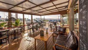 a restaurant with tables and chairs on a deck at Mareta Beach - Boutique Bed & Breakfast in Sagres