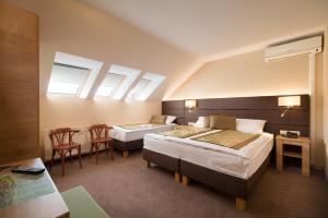 Postel nebo postele na pokoji v ubytování Hotel Honti Wellness és Konferencia Szálloda