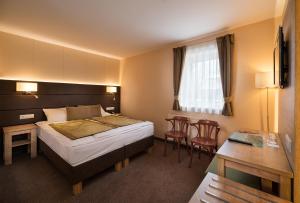 Postel nebo postele na pokoji v ubytování Hotel Honti Wellness és Konferencia Szálloda