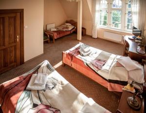マルボルクにあるHotel Stary Malborkのベッド2台と窓が備わるホテルルームです。