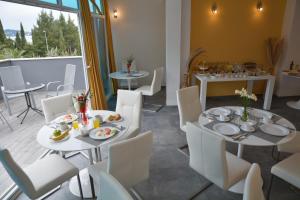 a dining room with white tables and white chairs at Villa Avantgarde in Mlini