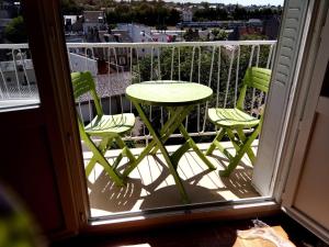 d'une table et de chaises vertes sur un balcon dans l'établissement Grand T2 pour Déplacement professionnel, stage, famille-, à Nevers