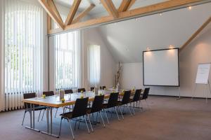 a conference room with a table and chairs and a whiteboard at Golfhotel Fahrenbach in Tröstau