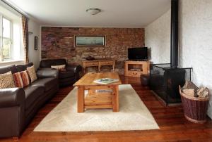 a living room with a couch and a fireplace at Long Barn Holiday Cottages in Newton Abbot