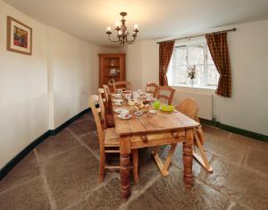 comedor con mesa de madera y sillas en Long Barn Holiday Cottages, en Newton Abbot