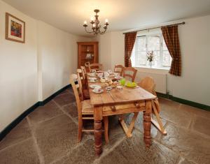 a dining room with a wooden table and chairs at Long Barn Holiday Cottages in Newton Abbot