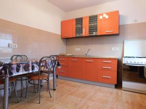 a kitchen with red cabinets and a table with chairs at Garsoniera Luxury in Sibiu