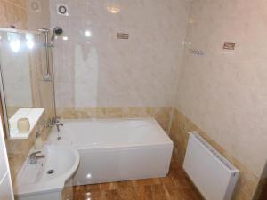 a bathroom with a white tub and a sink at Garsoniera Luxury in Sibiu