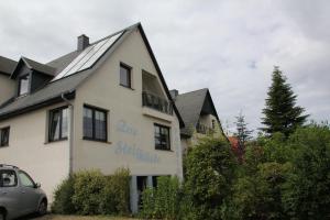 een huis met een auto ervoor geparkeerd bij Pension "Zur Steilküste" in Boltenhagen