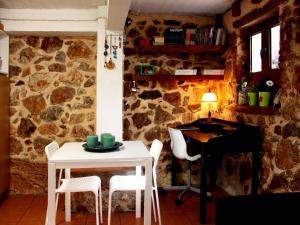 a table and chairs in a room with a stone wall at Sweet stone apartment in Imittos in Athens