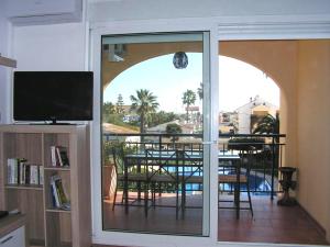 een woonkamer met uitzicht op een tafel en een balkon bij Golden Park in Denia
