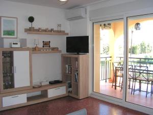 een woonkamer met een tv en een glazen schuifdeur bij Golden Park in Denia