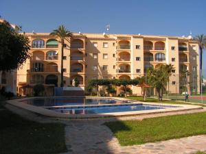 a building with a swimming pool in front of a building at Golden Park in Denia