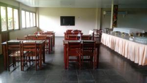 Cuca Legal Hotel في بريزدنته فيغويردو: غرفة طعام بها طاولات وكراسي وتلفزيون