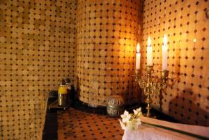 un bagno con una parete piastrellata con due candele di Riad Ibn Battouta & Spa a Fes Altre 37 foto