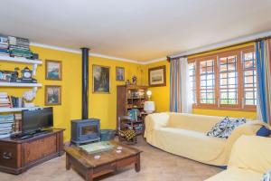 a yellow living room with a couch and a tv at Ca Na Carme (Alaronera) in Alaró
