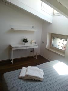 a bedroom with a bed with a window and a table at B&B Bergamo Alta in Bergamo