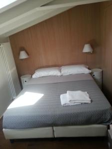 1 dormitorio con 1 cama y 2 toallas blancas en B&B Bergamo Alta, en Bérgamo