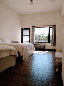 a bedroom with two beds and a large window at Summer Homestay in Kenting