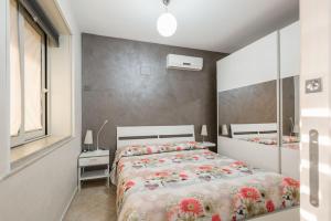 Un dormitorio con dos camas y un espejo. en Calabernardo Home Malacala, en Calabernardo