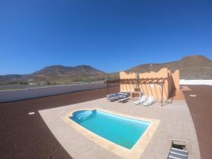 a swimming pool on a patio with mountains in the background at Casa Caliche in La Lajita