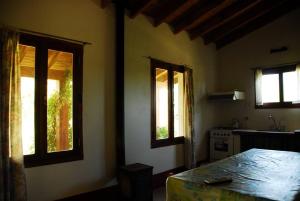 a kitchen with two windows and a table and a sink at Rancho La Peregrina in Nono