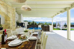 jadalnia z drewnianym stołem i krzesłami w obiekcie Caramel Villa, with 40m2 Pool & Spa Whirlpool, By ThinkVilla w mieście Panormos