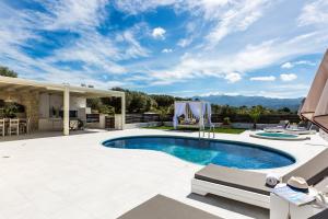 パノルモス・レティムノにあるCaramel Villa, elegant escape, By ThinkVillaのパティオ付きの庭のスイミングプール