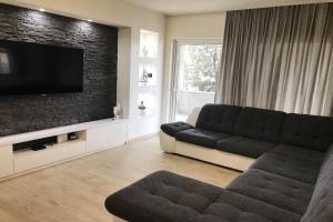 a living room with a couch and a flat screen tv at Apartments Villa Stivan in Solin