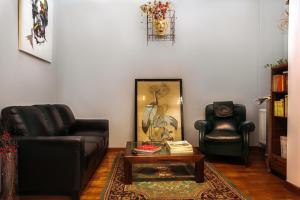 een woonkamer met 2 lederen stoelen en een salontafel bij Albergo Al Viale in Trieste