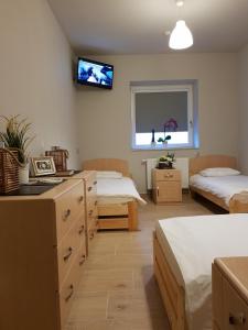 a room with two beds and a tv on the wall at lemon in Mielec