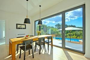 a dining room with a table and chairs and a pool at Villa Vala in Svetvinčenat