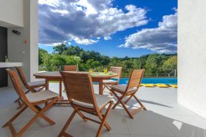 a dining room with a table and chairs on a patio at Villa Vala in Svetvinčenat