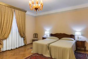 A bed or beds in a room at Villa Fenaroli Palace Hotel