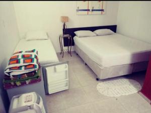 a bedroom with two beds and a trash can at Pousada Villas in Sorocaba