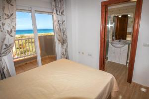 sypialnia z łóżkiem i umywalką oraz balkon w obiekcie Seychelles Two Bedroom Apartment RP043 w mieście La Manga del Mar Menor