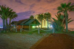 dom na plaży z budynkiem i palmami w obiekcie Seychelles Two Bedroom Apartment RP043 w mieście La Manga del Mar Menor