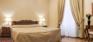 A bed or beds in a room at Villa Fenaroli Palace Hotel