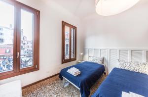 1 dormitorio con 2 camas y ventana en Ca' d'Oro suite, en Venecia